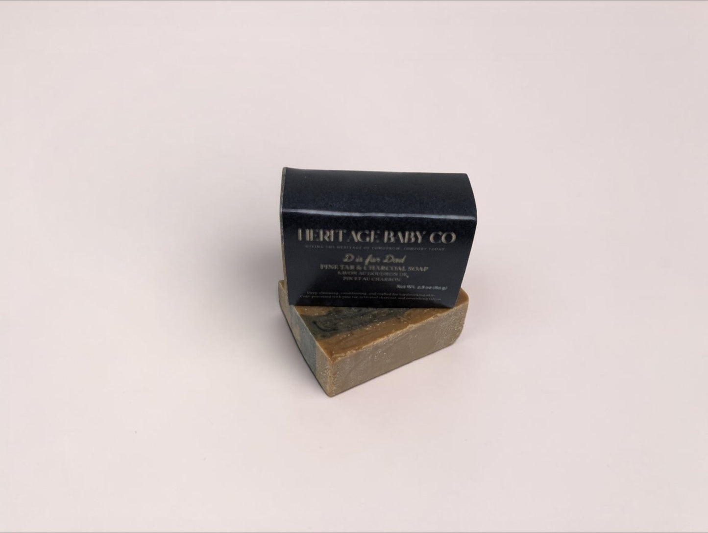 Heritage Baby Co. Pine Tar & Charcoal Soap bar with black packaging, featuring natural tallow and earthy ingredients.